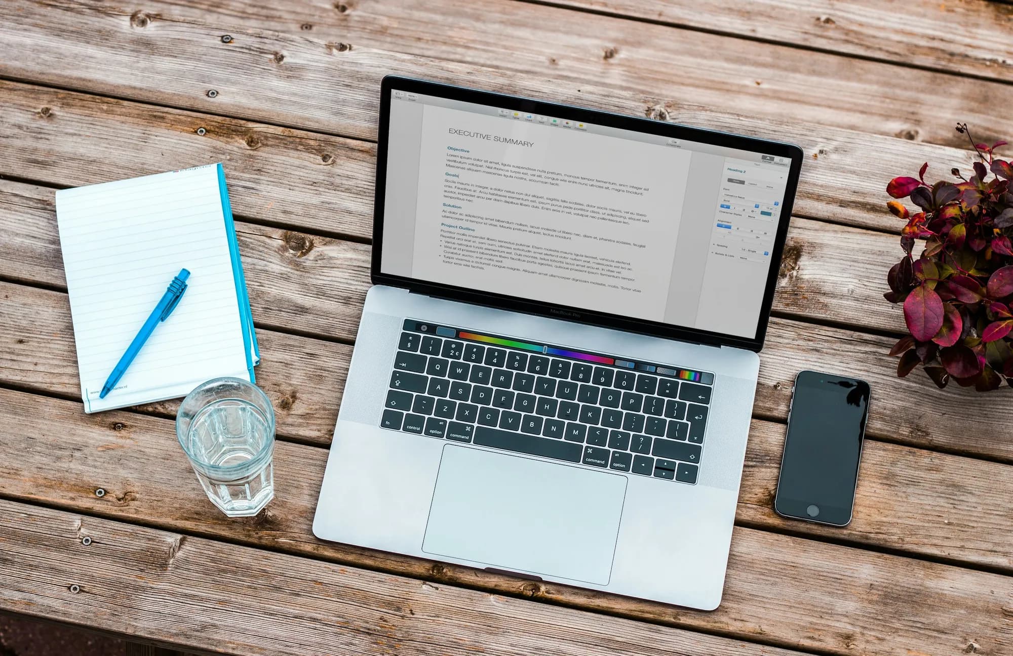 A checklist notebook and laptop on a desk