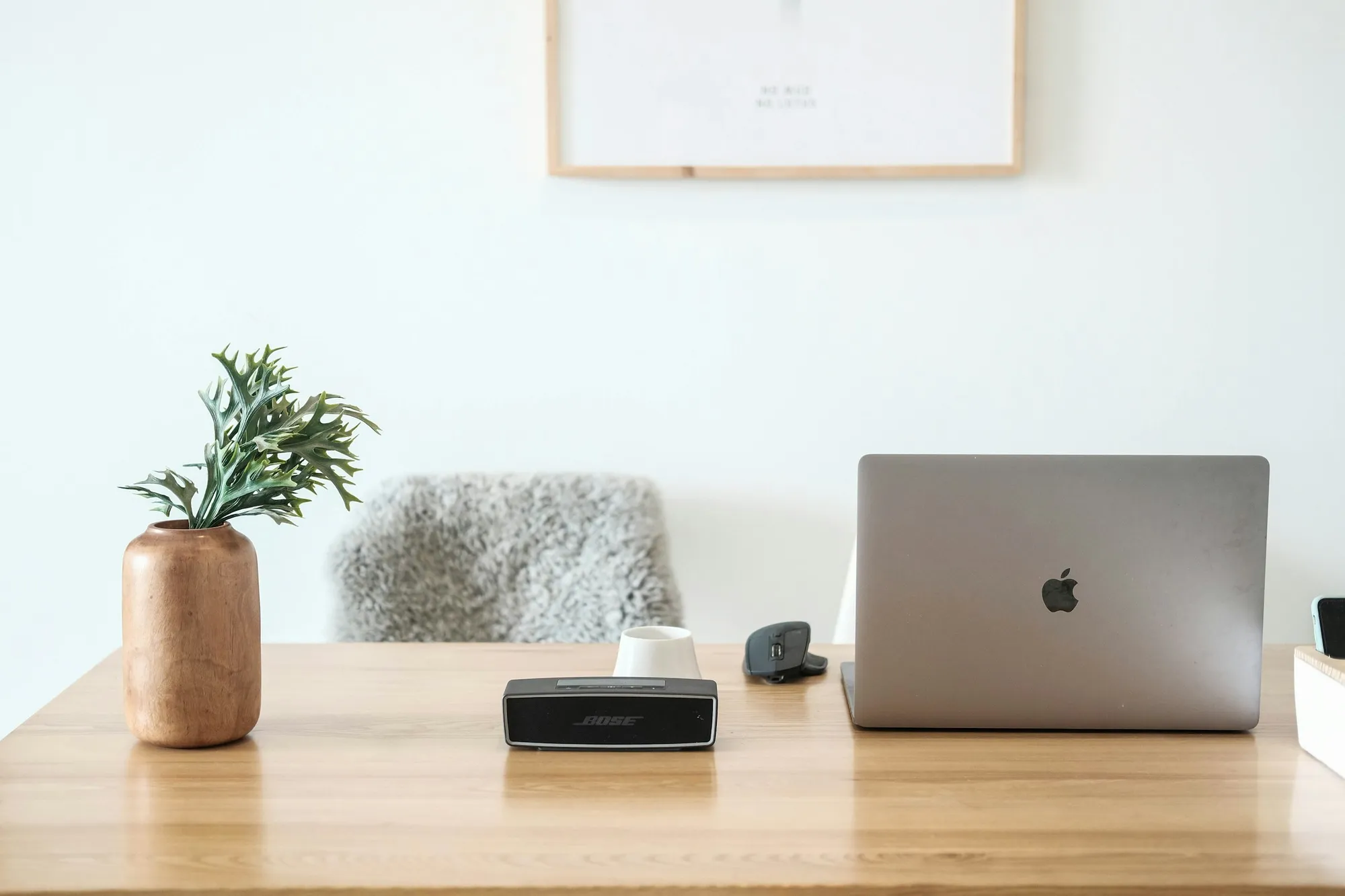 A minimal desk with a laptop, phone and notebook