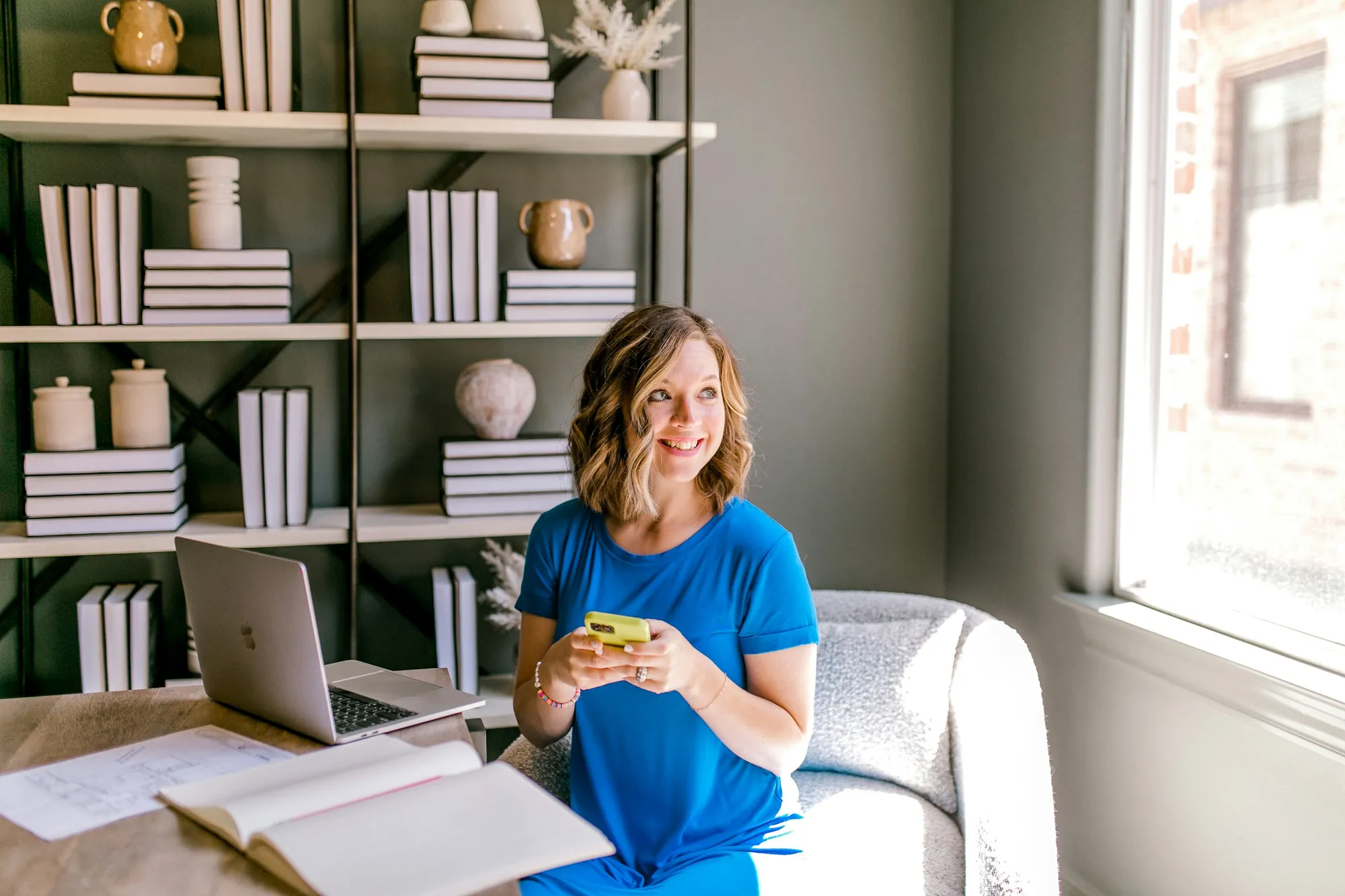 A home office with a bookshelf and laptop