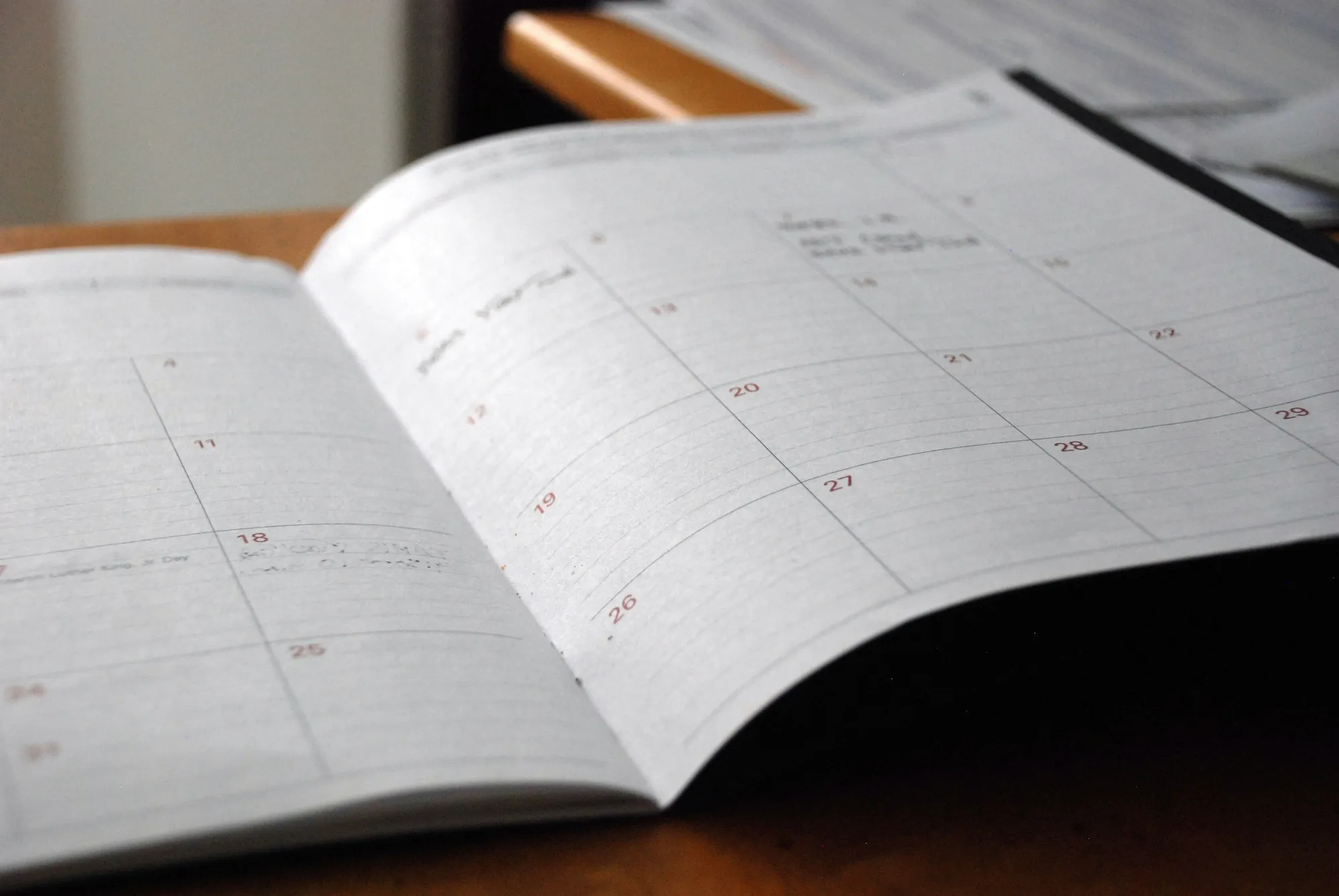 A calendar beside a laptop on a desk