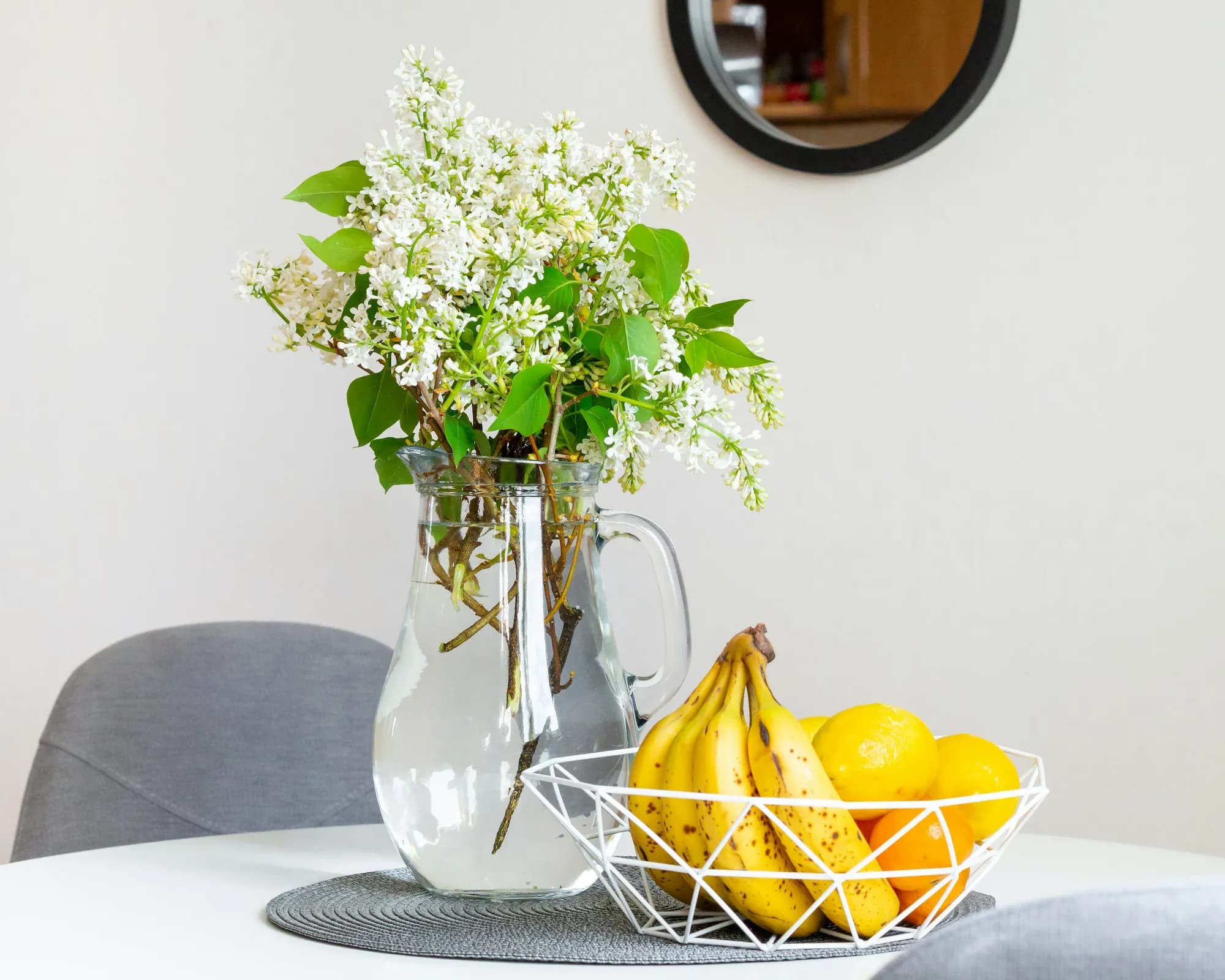 A welcome basket of fruit and flowers on a kitchen table