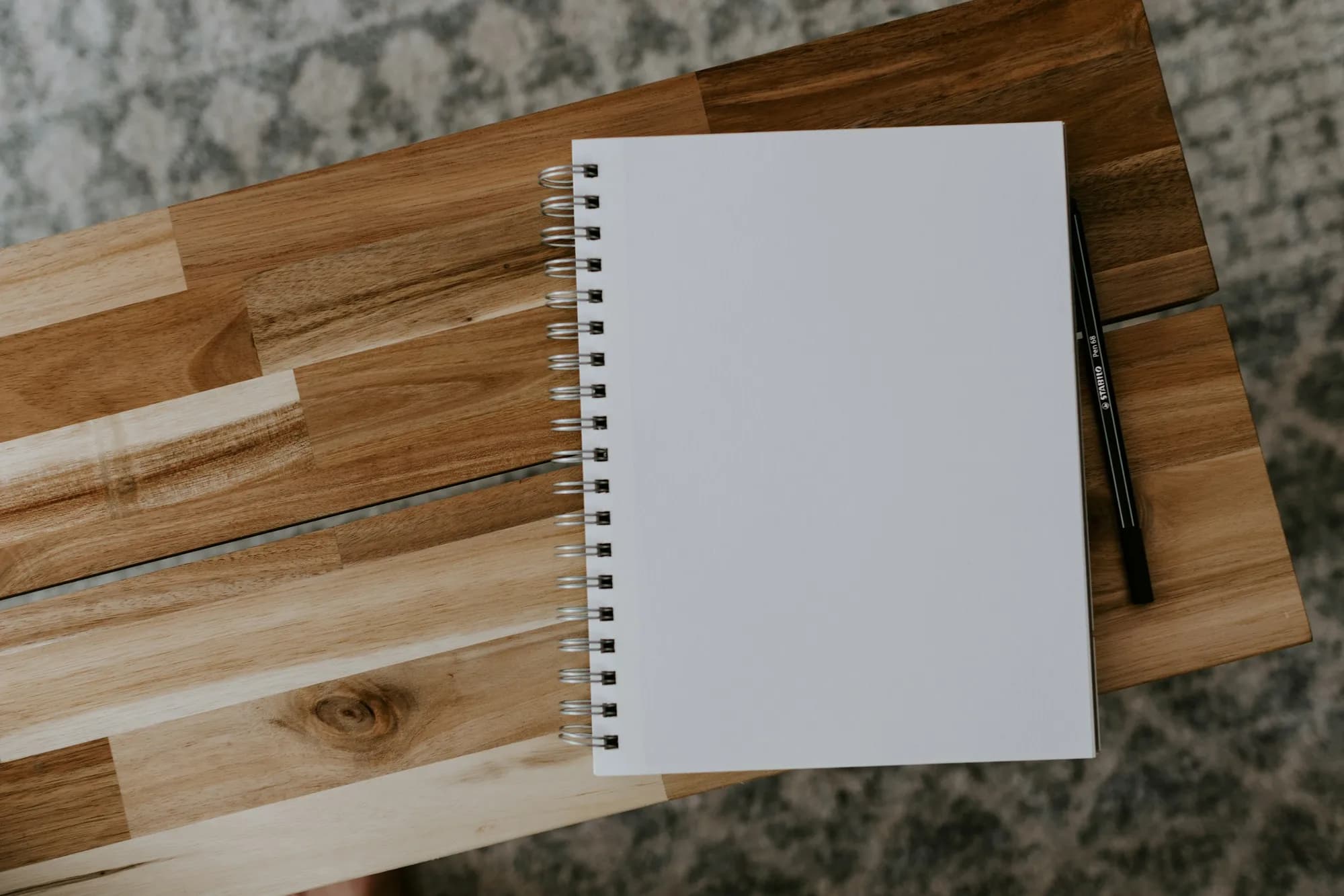 A pen and notebook on a desk seen from above