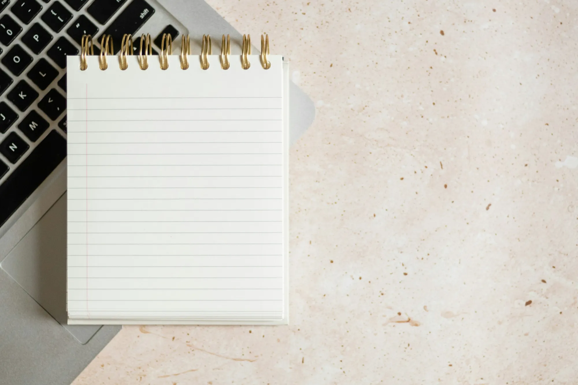 A notebook and laptop on a desk for planning a decision