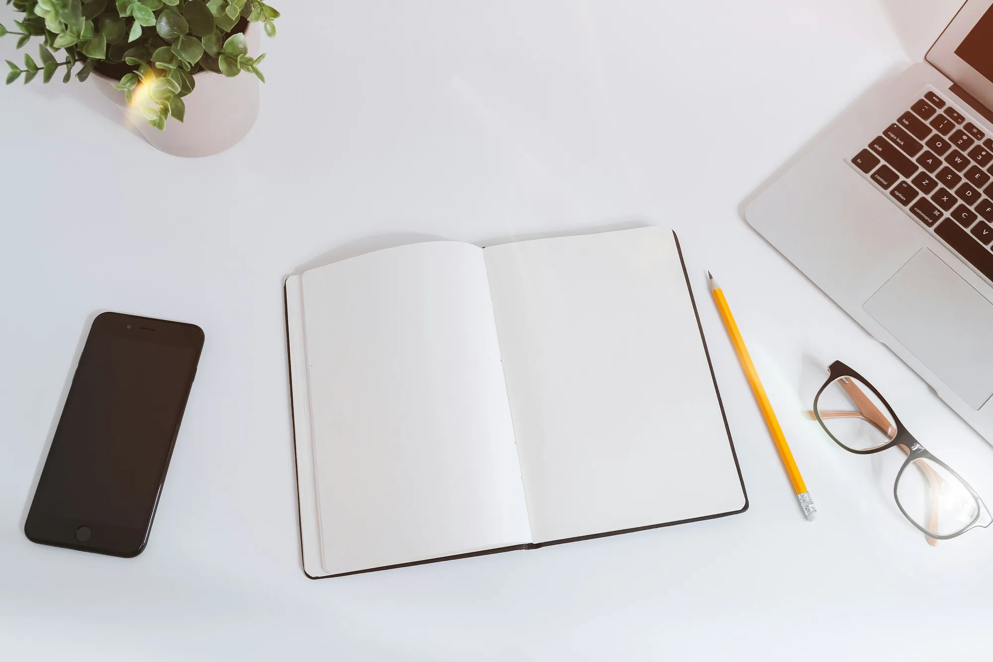 A laptop and notebook side by side on a desk