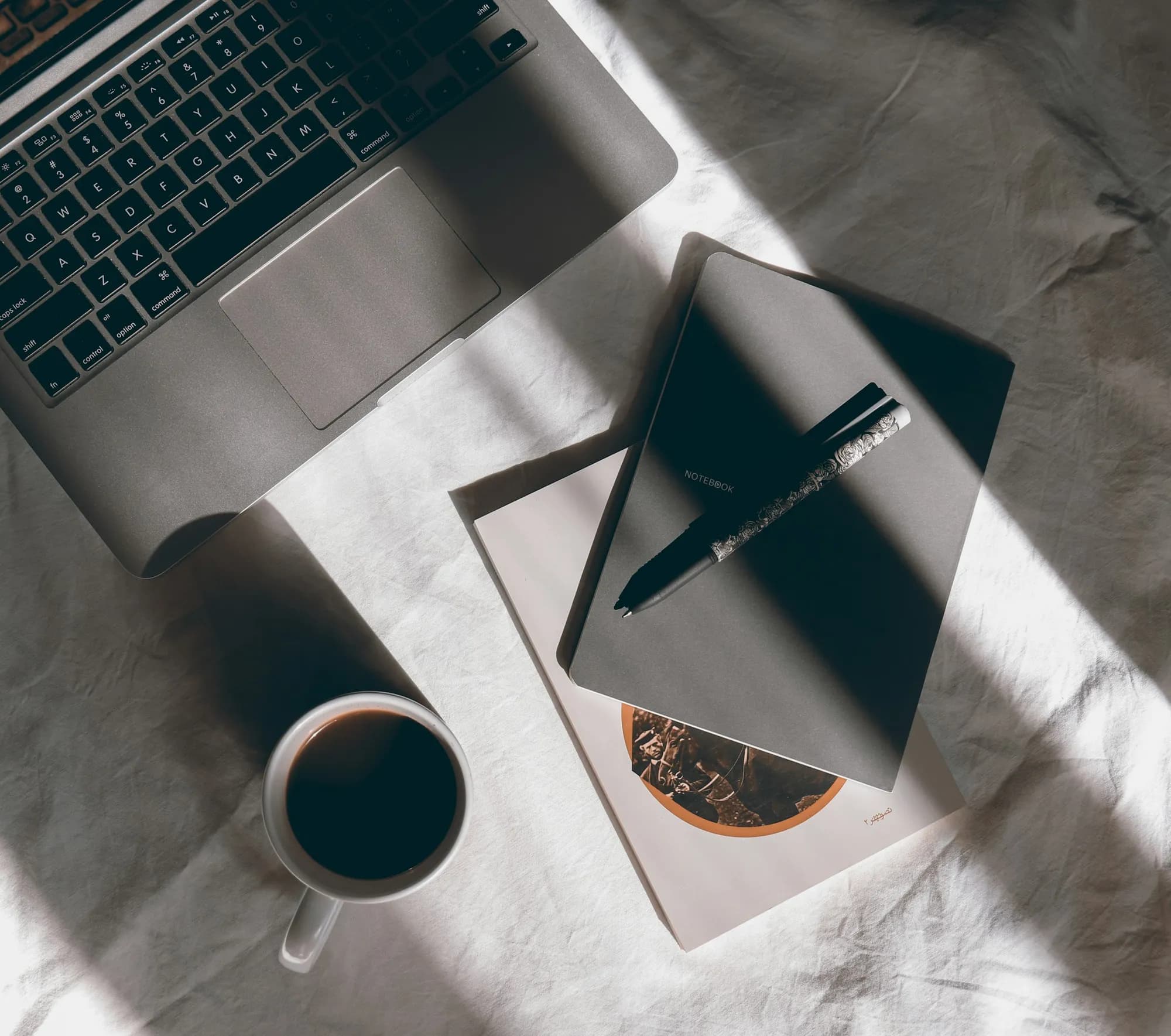 A notebook and laptop on a desk for planning a decision
