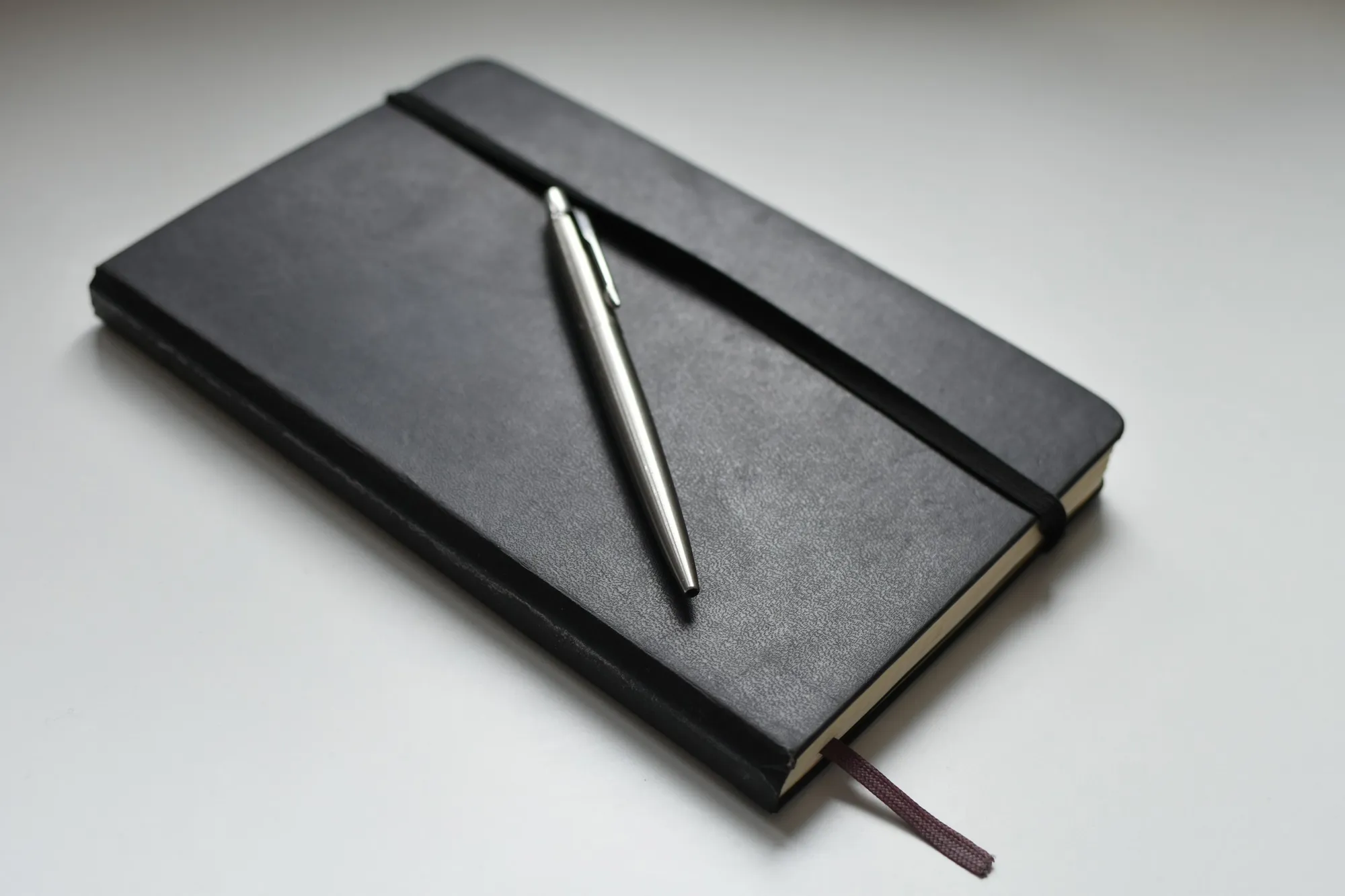 A notebook and laptop on a desk for planning a decision